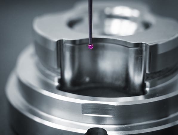 Coordinate measuring probe inspecting a precision-machined metal component